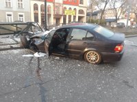 Na zdjęciu widoczny czarny pojazd marki BMW z rozbitym przodem. Samochód &amp;quot;wbity&amp;quot; w wiatę przystanka.