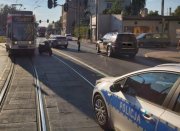 Miejsce wypadku, tramwaj i jednoślad stoją na skrzyżowaniu, policjant ruchu drogowego zabezpiecza ślady