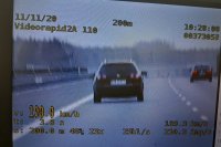 Na obrazku pokazano zdjęcie wideorejestratora , na który widać jadący ciemny samochód osobowy, obok jest zapisana prędkość 190 kilometrów na godzinę.