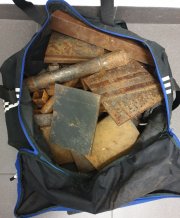 Na zdjęciu są widoczne metalowe, zardzewiałe elementy, które umieszczone są w granatowej, z niebieską obwódką torbie sportowej.