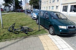 Miejsce zdarzenia, na trawniku leży rower, obok stoi samochód sprawcy a za nim radiowóz policyjny