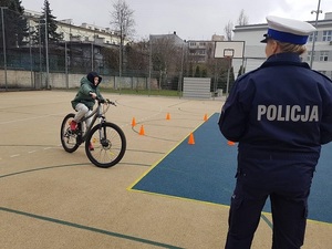 Policjantka oceniająca poprawność pokonaniu toru przez rowerzystkę.