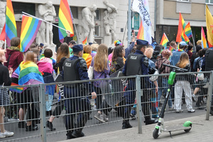 Marsz Równości. Uczestniczy przechodzą ulicami miasta w otoczeniu policjantów.
