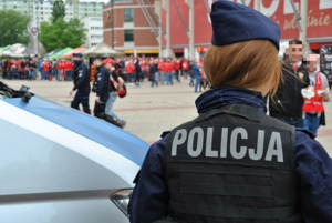 Policjantka obserwująca tłum kibiców przed stadionem Widzewa Łódź.