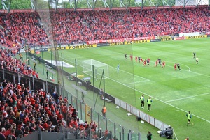 Stadion Widzewa Łódź na którym odbywa się mecz wraz z trybunami pełnymi kibiców.