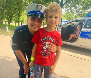 Policjantka z dzieckiem biorącym udział w festynie