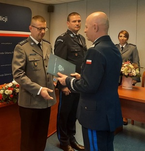 Komendant Główny Policji  składa gratulacje starszemu aspirantowi Rafałowi Zduniakowi obok którego stoi Komendant Miejski Policji w Łodzi inspektor Dariusz Dziurka.