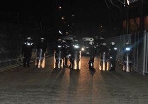 Oddział Prewencji Policji w Łodzi przed stadionem w otoczeniu pojazdów policyjnych.