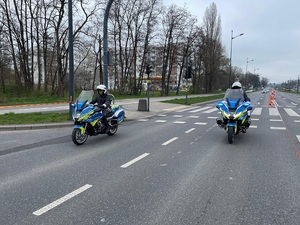 Policjanci na motocyklach jadą po trasie maratonu.