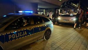 Radiowóz policyjny asystujący wejście piłkarzy ŁKS-u do autokaru po zakończonym meczu.