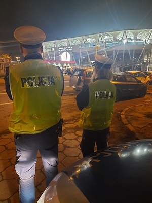 Policjanci Ruchu Drogowego przed radiowozem.