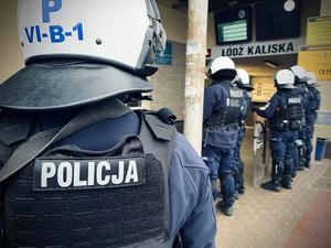 Policjanci stoją przed wejściem na dworzec Łódź Kaliska.
