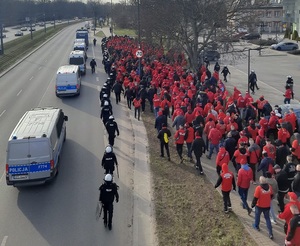 Policjanci zabezpieczają przemarsz kibiców Widzewa Łódź na stadion przy Alei Unii Lubelskiej.
