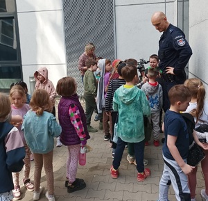 Policjant opowiada dzieciom jak ważne jest używanie elementów odblaskowych.