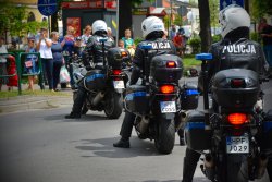 Trzech policjantów siedzi na motocyklach służbowych, stojących jeden za drugim.