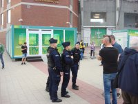 Na zdjęciu widać policjantów i kibiców stojących przed stadionem.