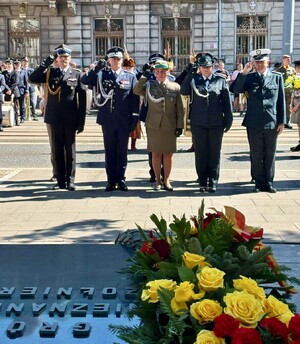 Przedstawiciele służb mundurowych składają wiązanki oddają honor.