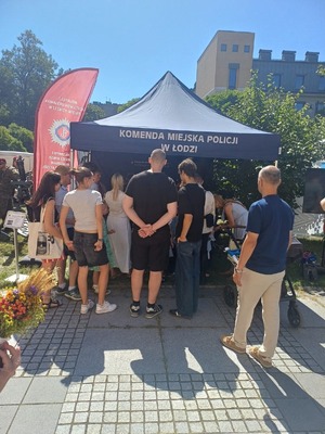 Mieszkańcy na stoisku promocyjnym Policji.