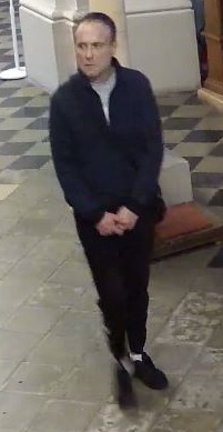 mężczyzna w wieku około 30 - 40 lat, włosy krótkie, ubrany w ciemno - granatową kurtkę i czarne spodnie