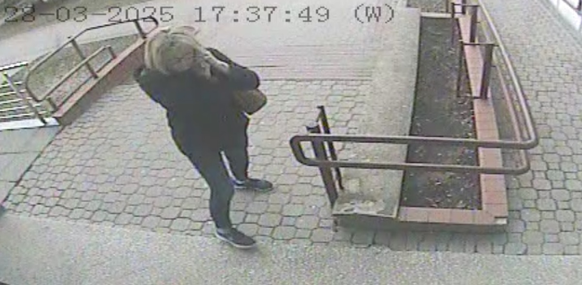 Kobieta stoi na chodniku. 