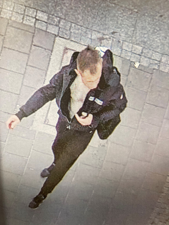 mężczyzna, wzrost około 170 centymetrów, wiek 35-40 lat, szczupła budowa ciała, krótkie włosy z widocznymi zakolami, ubrany w czarną kurtkę, czarne spodnie, czarne obuwie sportowe.