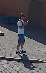 Mężczyzna miał na sobie biały t-shirt i niebieskie krótkie spodnie. 