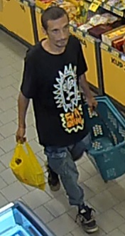 Sprawca kradzieży ma w ręku koszyk i reklamówkę.