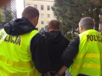 Zatrzymany mężczyzna prowadzony przez policjantów