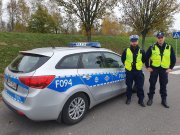 Policjanci na tle radiowozu