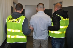 policjanci prowadzą zatrzymanego