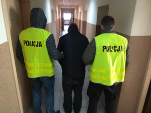 Policjanci prowadzą zatrzymanego sprawcę