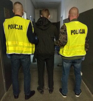 Policjanci prowadza zatrzymanego sprawce rozboju