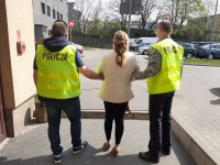 Na zdjęciu widzimy zatrzymaną kobietę , którą trzymają dwaj policjanci