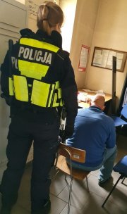 policjantka doprowadza zatrzymanego na przesłuchanie