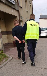 Policjant prowadzi nietrzeźwego kierowce do Komisraiatu