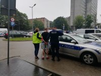 Policjanci wsadzają do auta zatrzymanego.