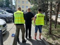 Zatrzymany sprawca konwojowany przez policjantów