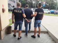 Zatrzymany sprawca konwojowany przez policjantów