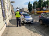 Na zdjęciu widzimy stojącego tyłem policjanta, który trzyma hulajnogę.