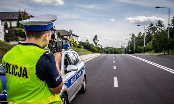 Policjant ruchu drogowego na drodze z radarowym miernikiem prędkości