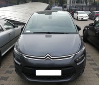 Na zdjęciu widoczny fragment parkingu policyjnego. Wśród aut stojących na parkingu widać znajdujący się na drugim planie oznakowany radiowóz policji. W centrum zdjęcia znajduje się pojazd marki Citroen  koloru grafitowego.