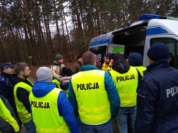 Policjanci podczas przygotowań do poszukiwań w lesie