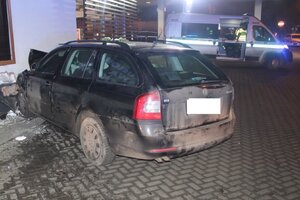 Na zdjęciu widoczny jest pojazd marki Skoda Octavia wbity w ścianę budynku stacji benzynowej. Pojazd jest koloru ciemnego. Za pojazdem widać radiowóz łódzkiej drogówki z włączonymi światłami błyskowymi. Zdjęcie wykonane w porze nocnej.