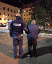 Policjant prowadzi zatrzymanego kierującego.