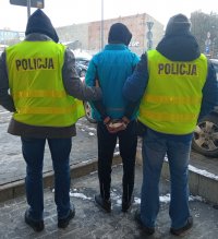 Policjanci prowadzą sprawcę kradzieży.