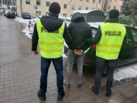 Policjanci prowadzą zatrzymanego.