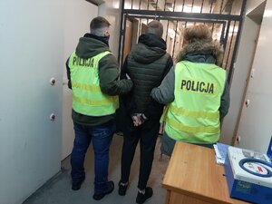 Policjanci prowadzą zatrzymanego.