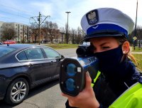 Policjantka mierzy prędkość pojazdów.