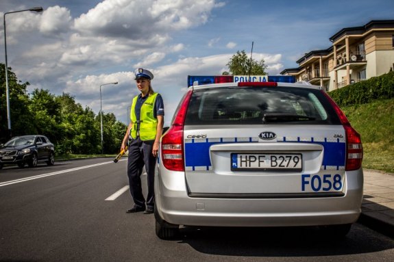 Policjant stoi przy radiowozie