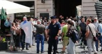 Manifestujący w okolicach Pasażu Rubinsteina. Policjant zabezpiecza tworzące się zgromadzenie